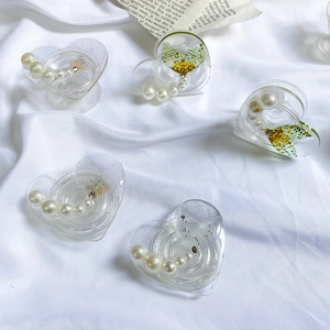 Detailed view of heart-shaped phone grips with pearls, glitter, and dried flowers