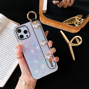 Glitter iPhone case with gold bees, pearl wrist strap and ring holder on black backdrop