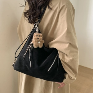 Large black triangle tote bag in matte suede with decorative silver zipper and plush charm
