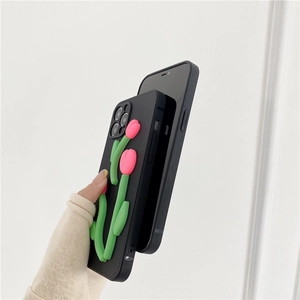 Detail of hand holding black phone case featuring a 3D pink tulip floral design