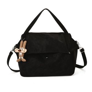 Minimalist black tote bag with wide handles, detachable strap and cute rabbit pendant
