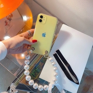 Detail of transparent phone case with thick faux pearl wrist strap and metal rings