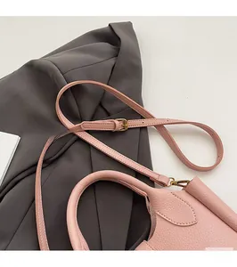 Detail of pink lychee leather texture with adjustable strap and vintage gold buckle