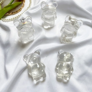 Gros plan de supports ours transparents sur soie blanche avec perles et feuilles