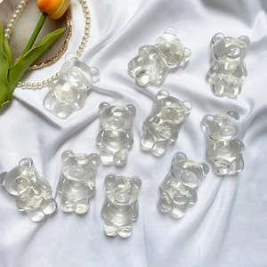 Gros plan de supports ours transparents mignons avec inserts floraux sur soie blanche