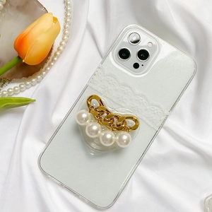 Detail of glitter phone case with lace, gold chain, pearls and heart-shaped grip