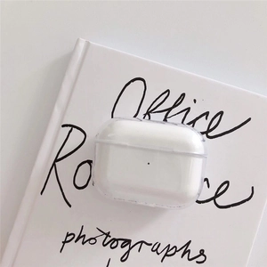 Minimalist clear acrylic case for AirPods Pro on a white book with black script text