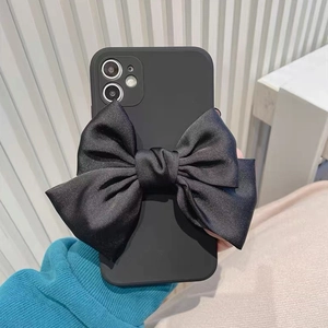 Detailansicht einer mattschwarzen iPhone Hülle mit großer Satinschleife in der Hand