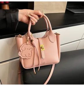 Pink lychee grain leather bucket bag with gold metal twist lock and cute dog pendant charm