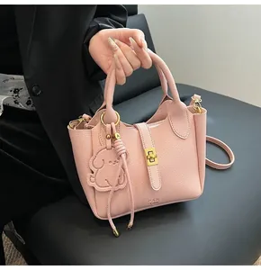 Pink lychee grain leather bucket bag with gold hardware and cute animal charm