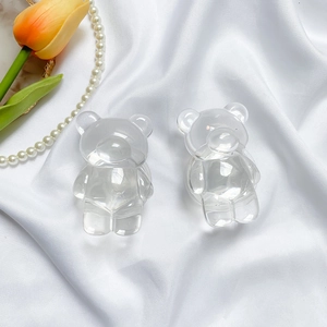 Gros plan du support de téléphone ours transparent sur soie blanche avec tulipe et perles
