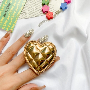 Close-up of heart-shaped gold phone socket with quilted lattice pattern and metal finish