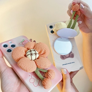 Detail of plush phone case with integrated vanity mirror and cute floral cherry design
