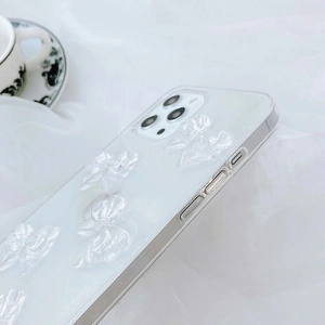 Close-up of translucent white iPhone case featuring 3D bows and shimmering glitter finish