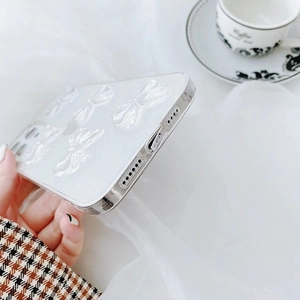 Detail of white glitter iPhone case featuring 3D bows and precise bottom charging port cutouts