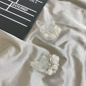 Macro detail of iridescent butterfly and white resin rose on a transparent phone grip