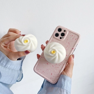 Detail of pink polka dot phone case with 3D steamed bun pop socket and cute charms