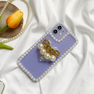 Purple iPhone case featuring pearl trim and a heart-shaped grip with gold chain detail