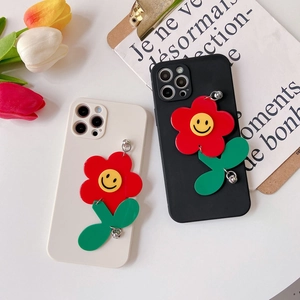 Close-up of iPhone case with a 3D sunflower pendant and floral charm details