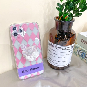 Detail showing the 3D butterfly, resin rose, and pearl charms on the phone case grip
