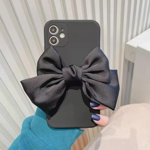 Matte schwarze Handyhülle mit großer Satinschleife, gehalten von einem Modell in Blau