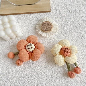 Detailed macro view of handmade fabric flower accessories with hanging green stems