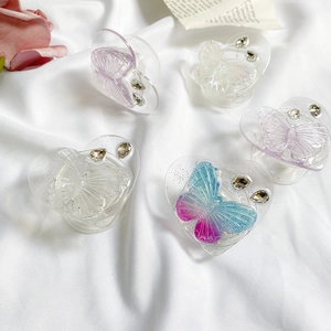 Detailed view of heart-shaped butterfly phone grips in assorted colors with rhinestones