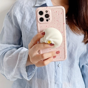 Detail of pink splattered phone case with 3D steamed bun pop socket held by a person