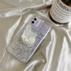 Close-up of a purple glitter phone case with 3D butterfly and rose grip on silk fabric
