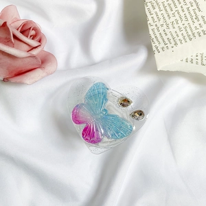 Detail of heart-shaped resin phone grip with blue gradient butterfly and rhinestones