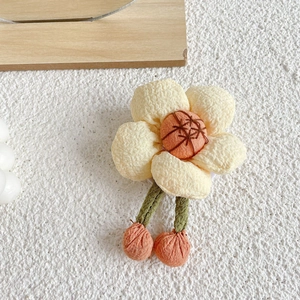 Detailed view of handmade floral fabric phone mirror with textured petals and orange accents