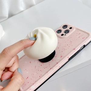 Close-up of flexible 3D bun-shaped grip on a pink splatter texture phone case