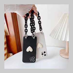 Detail of iPhone case with 3D heart motif and chunky black chain link strap accessory