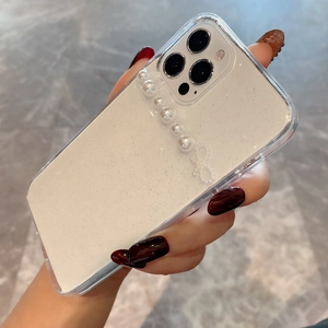 Handheld view of pearlescent white glitter iPhone case featuring elegant white pearl strap