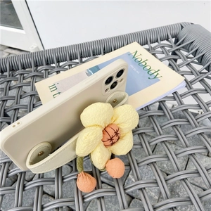 Detail of iPhone case with beige wrist strap and a large 3D yellow fabric flower