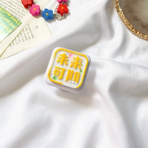 Detail of a square phone grip with floral accents and a yellow Future Is Bright relief