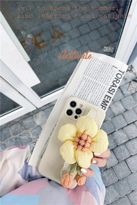 Detail showing cream iPhone case with a large 3D yellow fabric sunflower and hanging charm