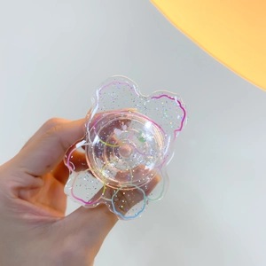 Detail of cute transparent acrylic bear phone grip with colorful glitter and wavy lines