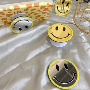 Collapsible round smile mirror phone socket stand in gold and silver mirror finishes