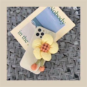 Beige iPhone case with a large 3D plush sunflower ornament and wrist strap