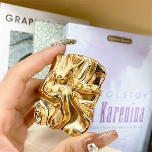 Close-up of gold irregular textured collapsible phone grip with metallic fluid ripple finish