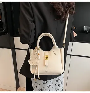 Detailed shot of lychee textured leather bucket bag with gold lock and puppy charm