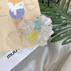 Macro shot of heart-shaped laser phone grip with 3D colorful bears and pearl heart