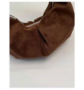 Close-up of the pleated suede texture and silver metal zipper on this brown leopard bag