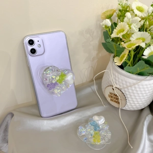 Close-up of heart-shaped phone grip with colorful resin pearls and cute bear charms