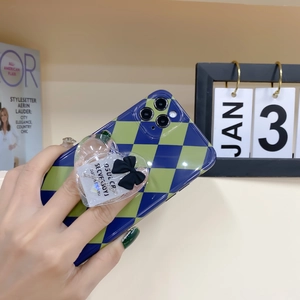 Detail of green checkerboard iPhone case with transparent heart grip and black bow design