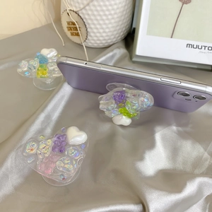 Detail of laser bear and pearl heart resin phone grips on silver satin fabric