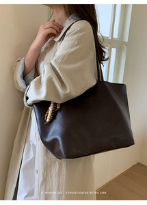 Detail of dark brown tote bag featuring retro wooden beads and soft textured leather