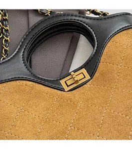 Close-up of golden twist lock and quilted faux suede texture on a crossbody bag