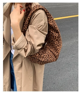 Detailed view of leopard print canvas hobo bag worn with a casual trench coat